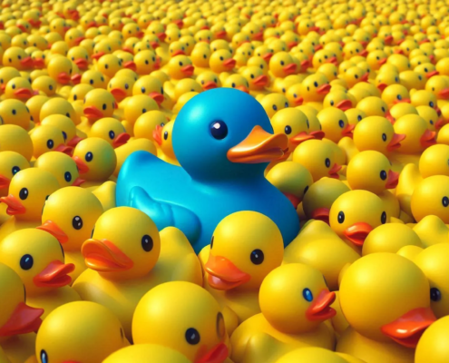 Eine größere blaue Plastik-Ente in einem Meer aus gelben Plastik-Enten symbolisiert die Bedeutung der Positionierung für Coaches, Heilpraktiker und Therapeuten.